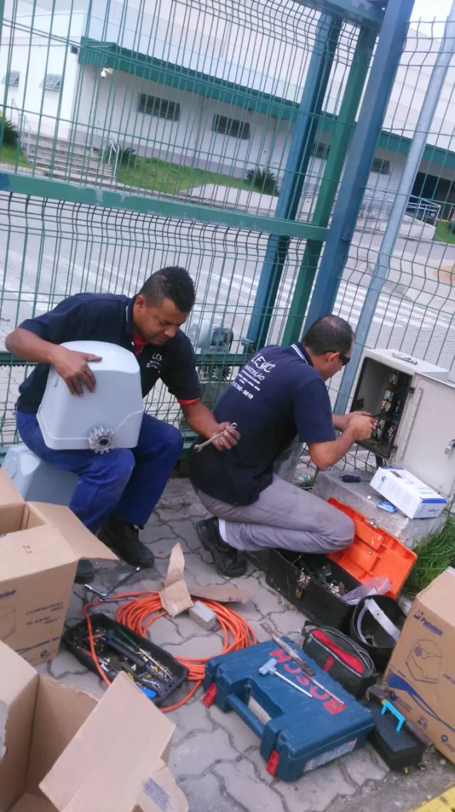 Equipe instalando automação em portão industrial