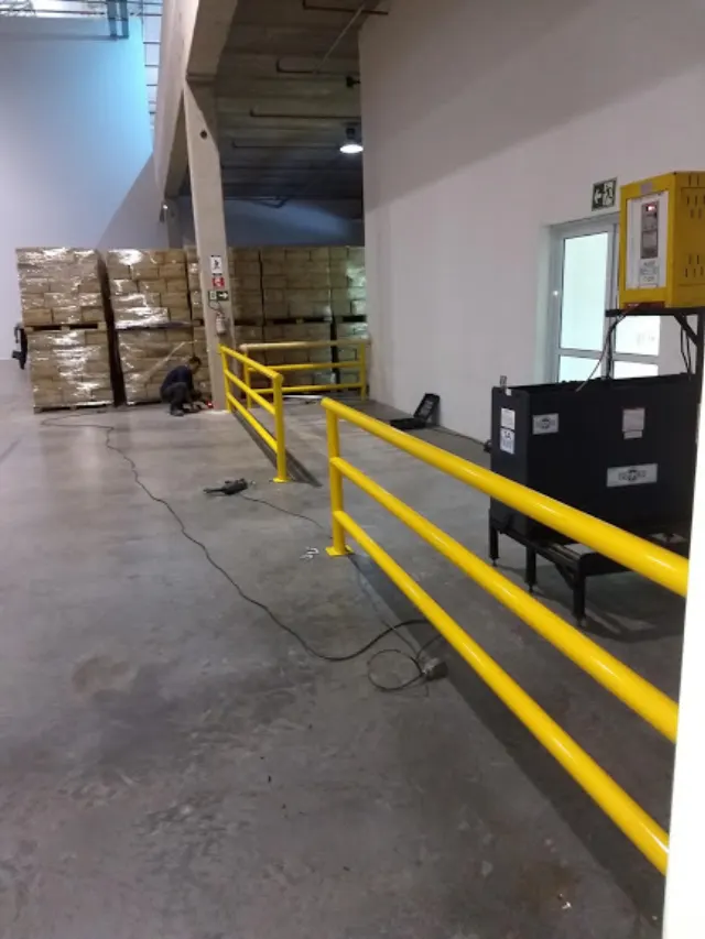 Guarda-corpo amarelo instalado em corredor logístico