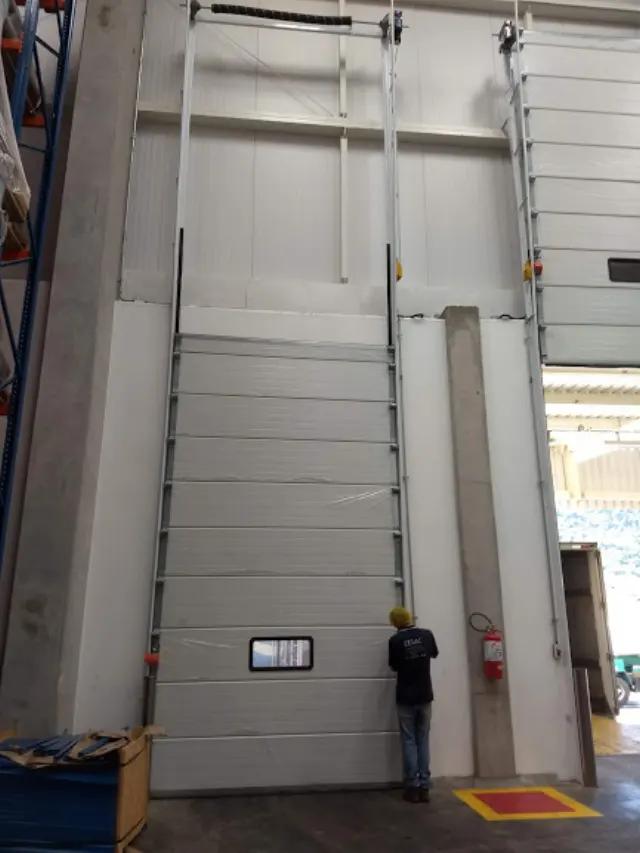 Profissional verificando uma porta industrial alta